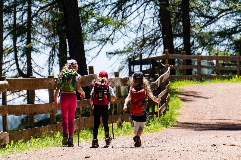 Kinder spielen draußen im Gras – Familienurlaub in der Hütte
