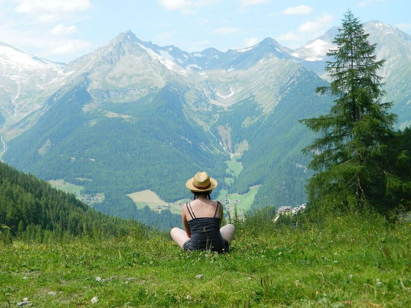 Alleinreisende auf dem Berg mit Blick über die Alpen