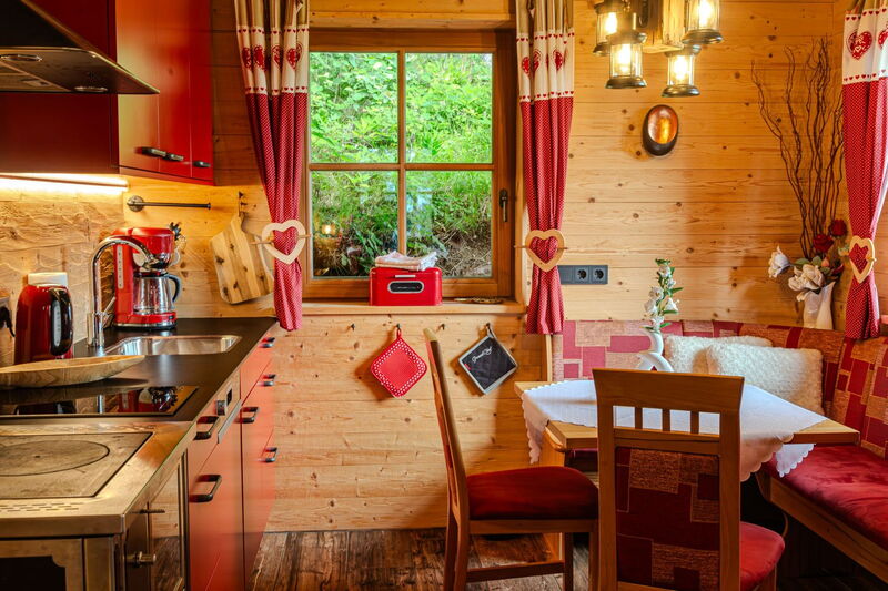 Wohnraum der Tiroler Hütte mit Holzofen und Zirbenbett