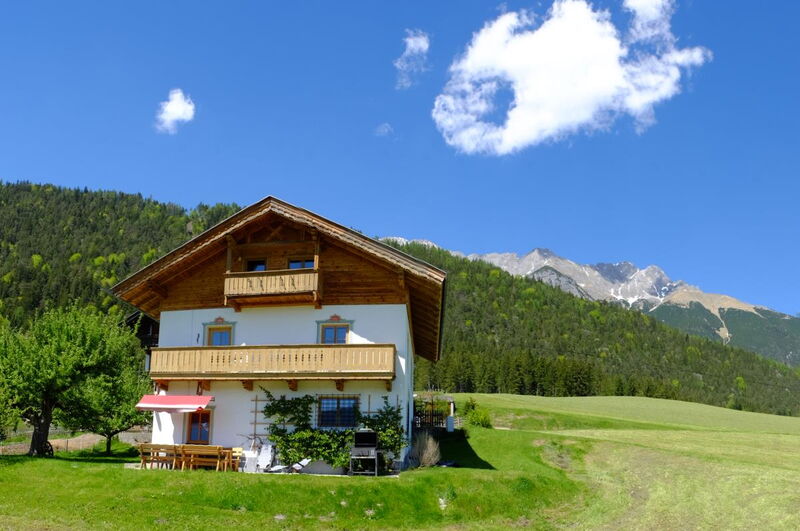 Grafenhäusl von vorne mit Balkon und Sonnenschirm, Ferienhaus für Familien und Freunde am Naturpark Karwendel