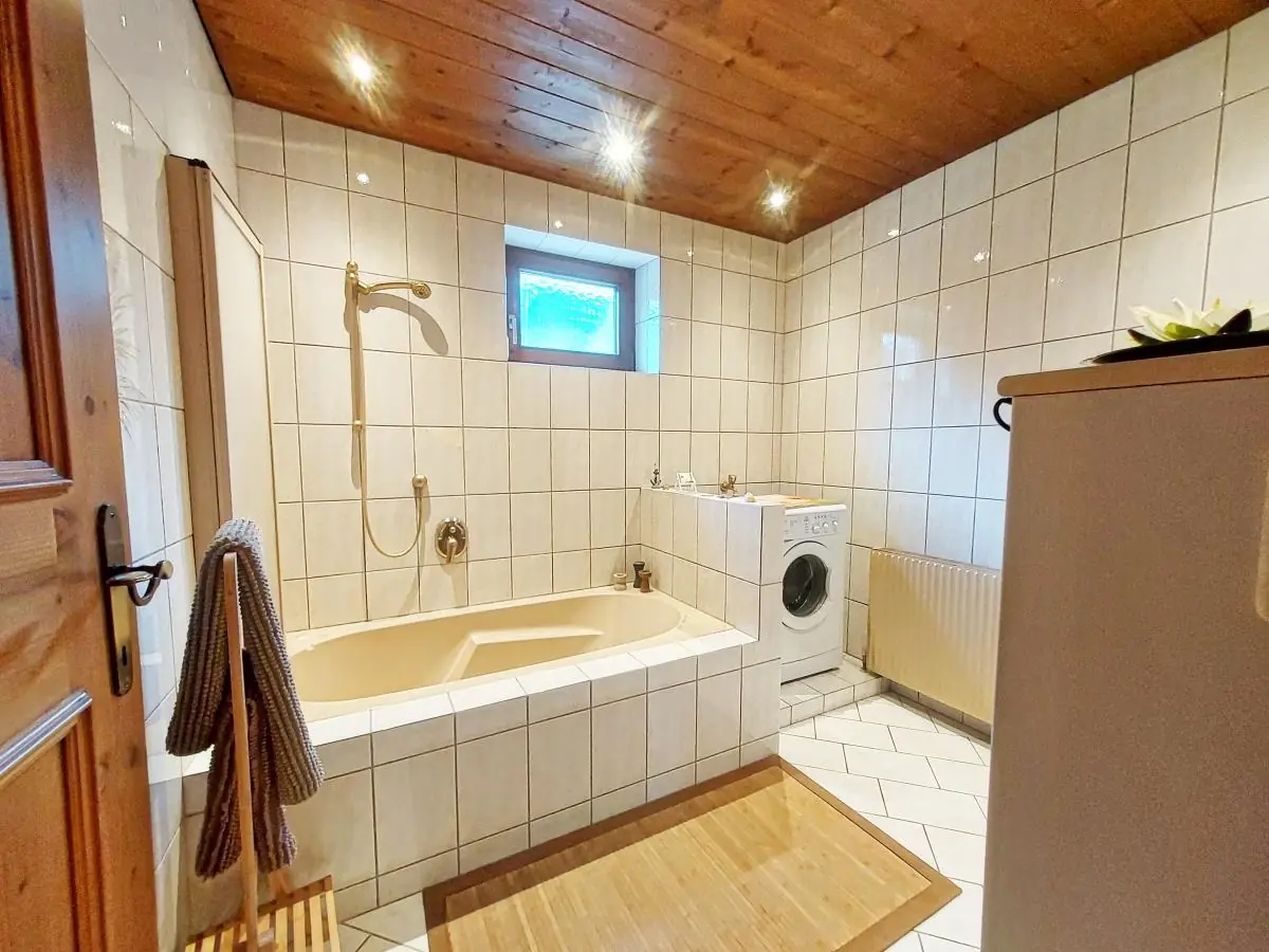 Badewanne unter der Holzdecke im Ferienhaus Alpenrehblick