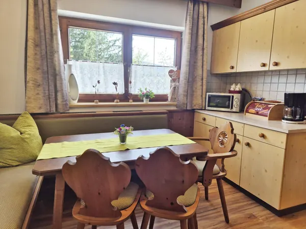 Küche mit Eckbank und Herzstühlen im Ferienhaus Alpenrehblick