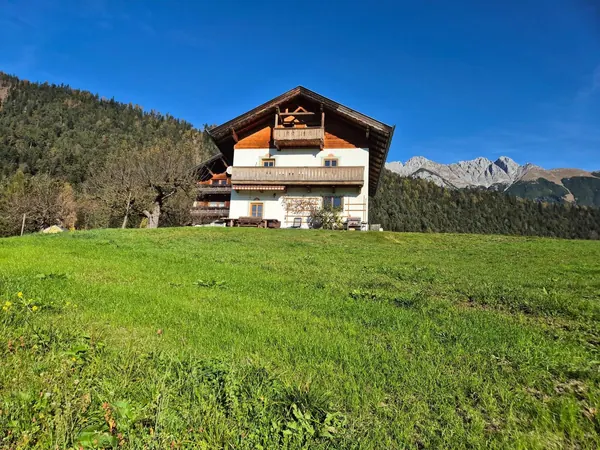 Das Grafenhäusl im Hochsommer über der steilen Bergwiese am Naturpark Karwendel