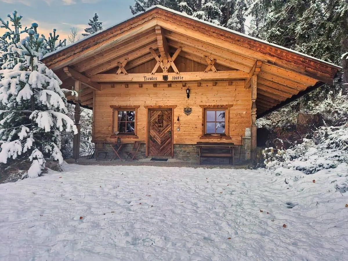 Tiroler Hütte im Schnee zwischen verschneiten Fichten am Umlberg bei Terfens