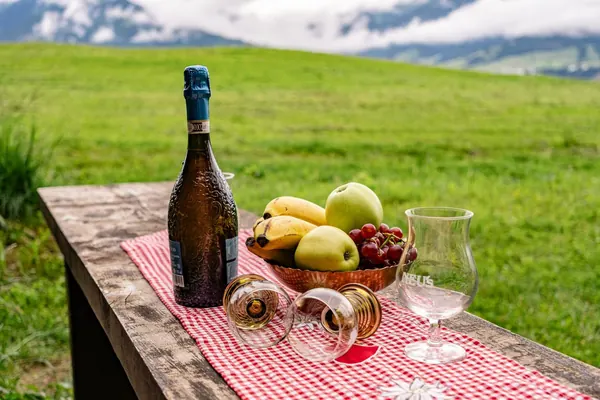 Jause mit Obst und Sekt auf der Holzbank vor dem Waldhüttl