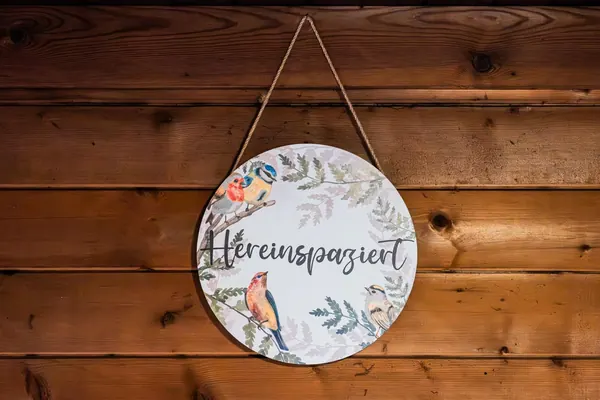 Schild „Hereinspaziert" an der Holzwand des Waldhüttl